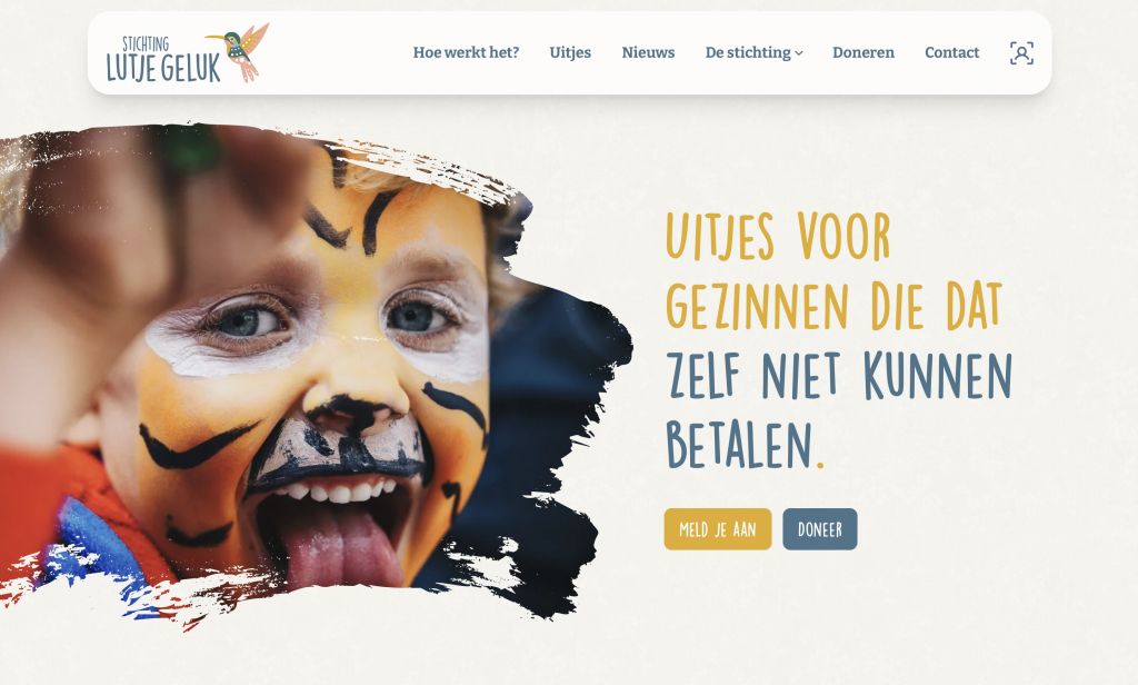 De hero-afbeelding van de website voor Lutje Geluk. Een lachend kindje met schmink en de tekst: "Uitjes voor gezinnen die dat zelf niet kunnen betalen. .